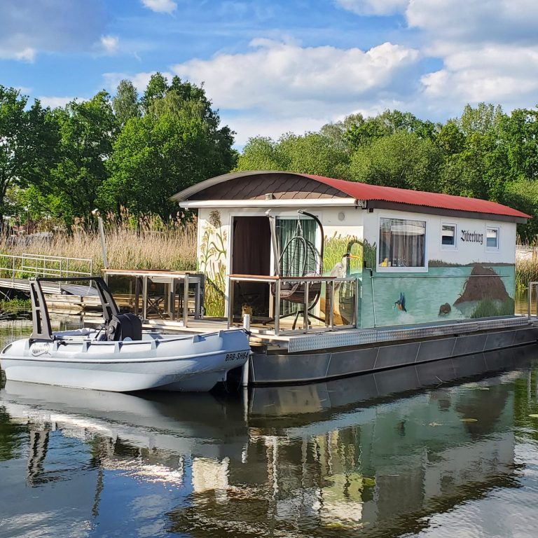 Bieberburg in Kützkow Bieberburg am Steg mit einem Beiboot vor einer malerischen Landschaft.